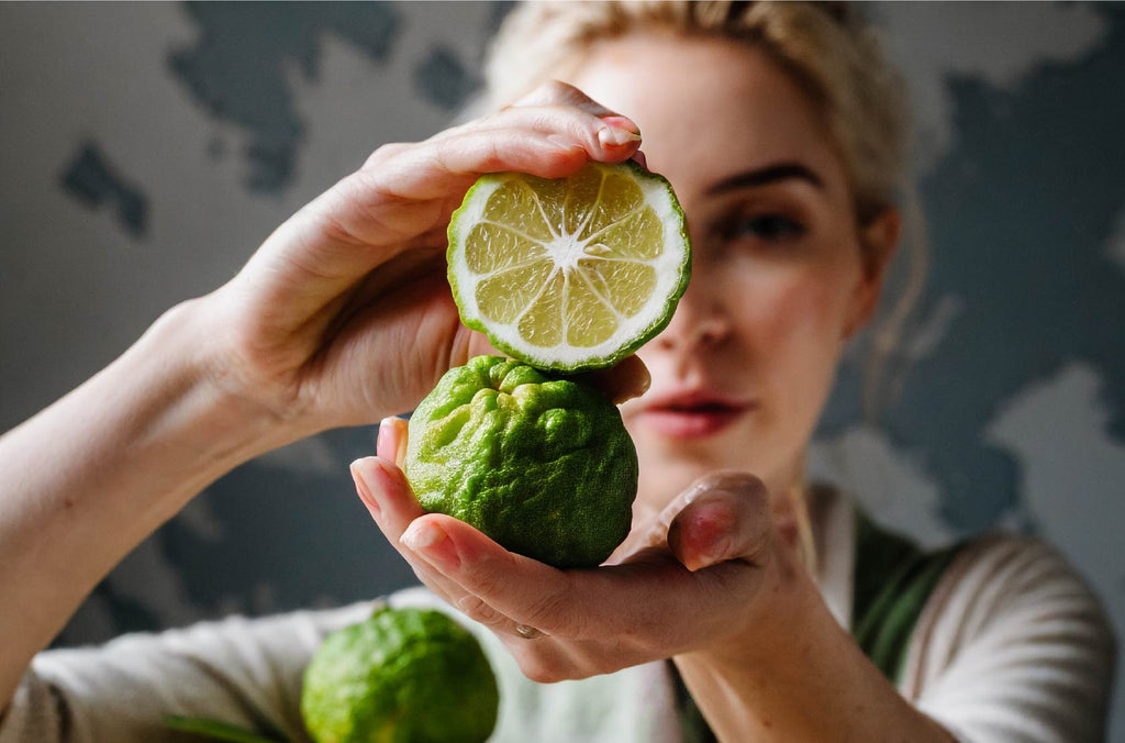 woman holding two bergamot with both hands