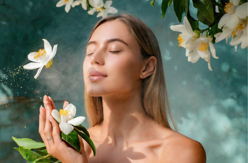 woman inhaling neroli scent in turquoise background