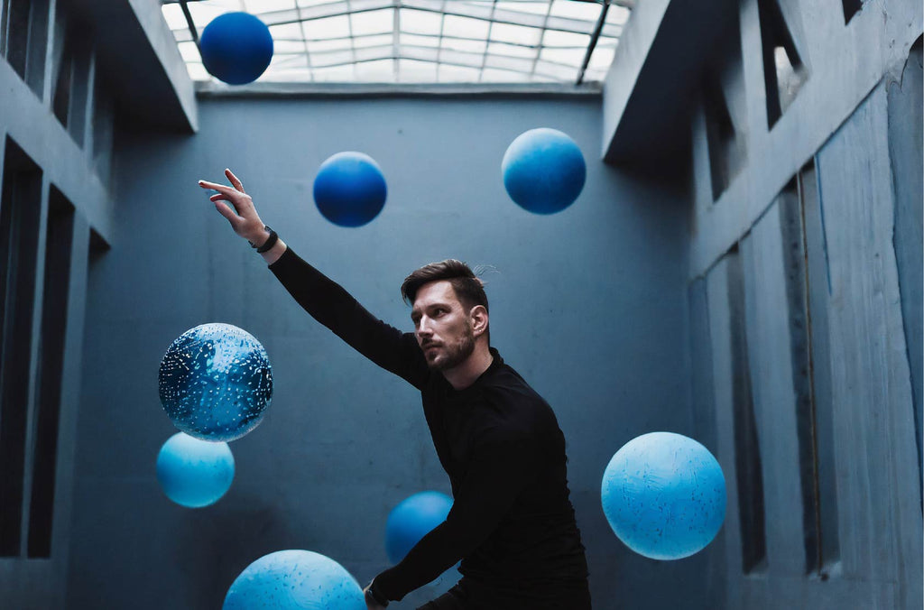 Man in blue space wth floating blue balls