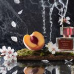 Whistle Moon natural cologne by Prosody London with peach and water splash on dark marble